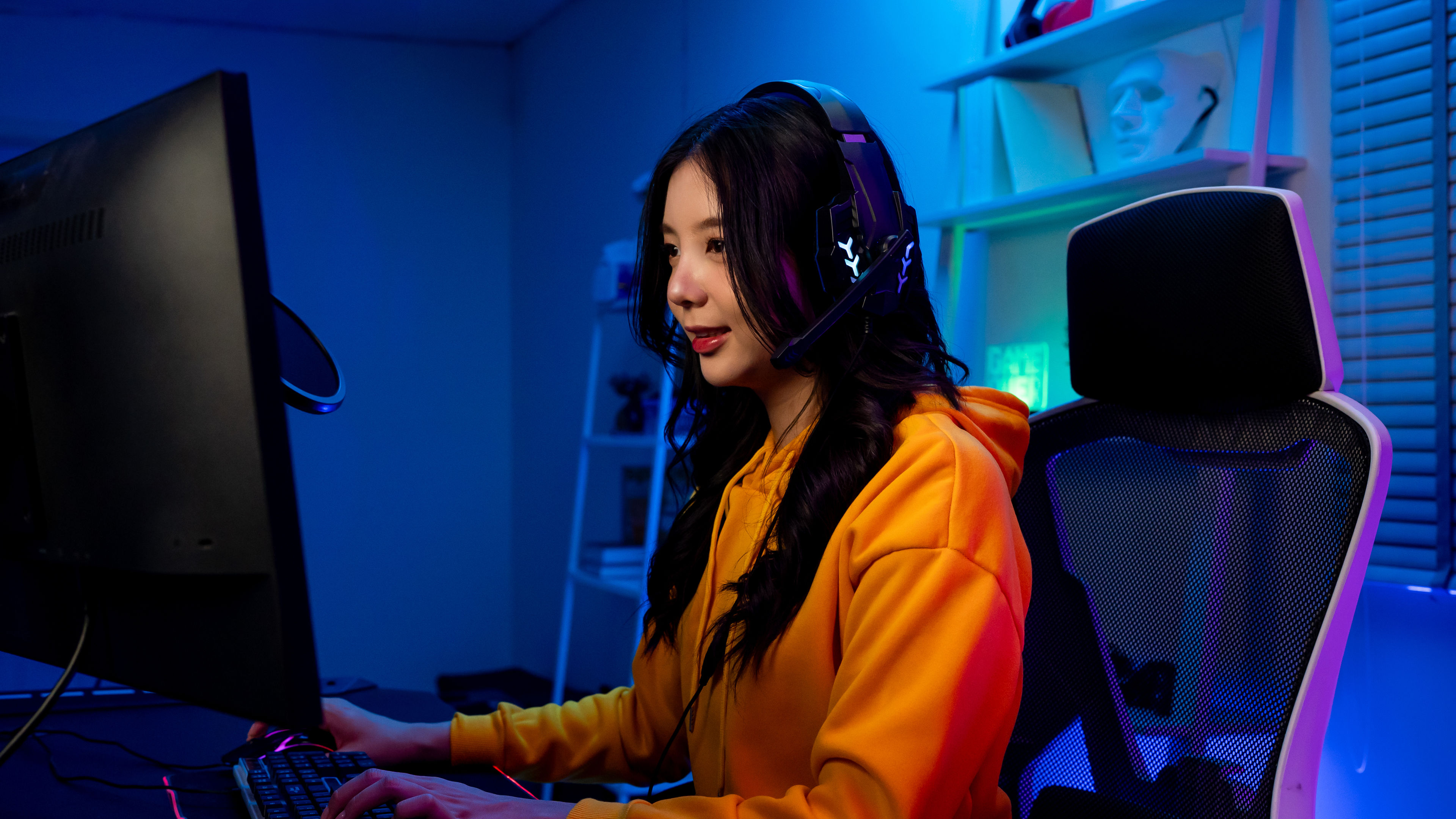 Asian beautiful teen gamer playing online video game on computer.